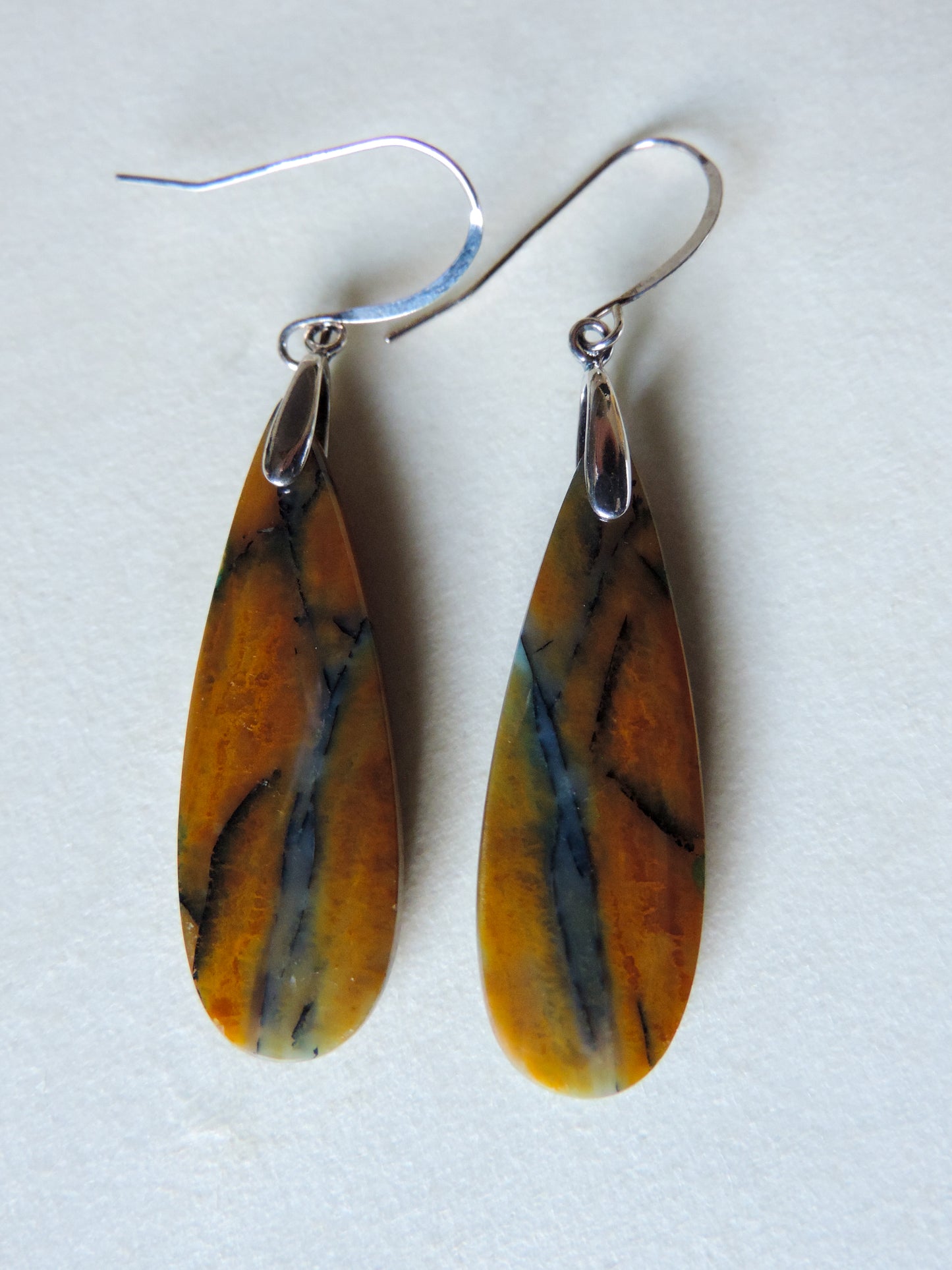 The bail and earring wires are authentic 925 sterling silver. Feel treasured when you wear these earrings!Extremely rare and lovely, Indonesian Blue Opalized Wood is a cherished material used by lapidary artists for creating stunning pieces of jewelry. The material was first found as pebbles and rounded stones in streams and near the slopes of three volcanoes in the West Java Province.