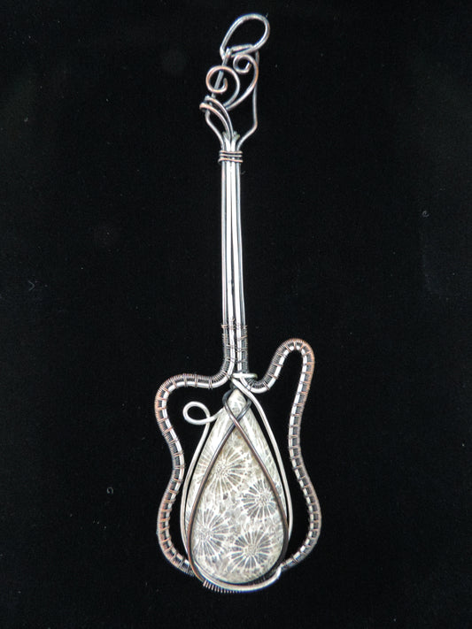 Indonesian Fossil Coral & Mixed Metal Guitar Pendant   Agatized fossil corals are found in several provinces across the Indonesian Islands of Sumatra and Java.  The fossil corals are remnants of ancient reefs thrust up onto the land mass by plate collisions.  Other discovery areas of well preserved agatized coral reefs are testament to the fact that sea levels were once much higher than today.