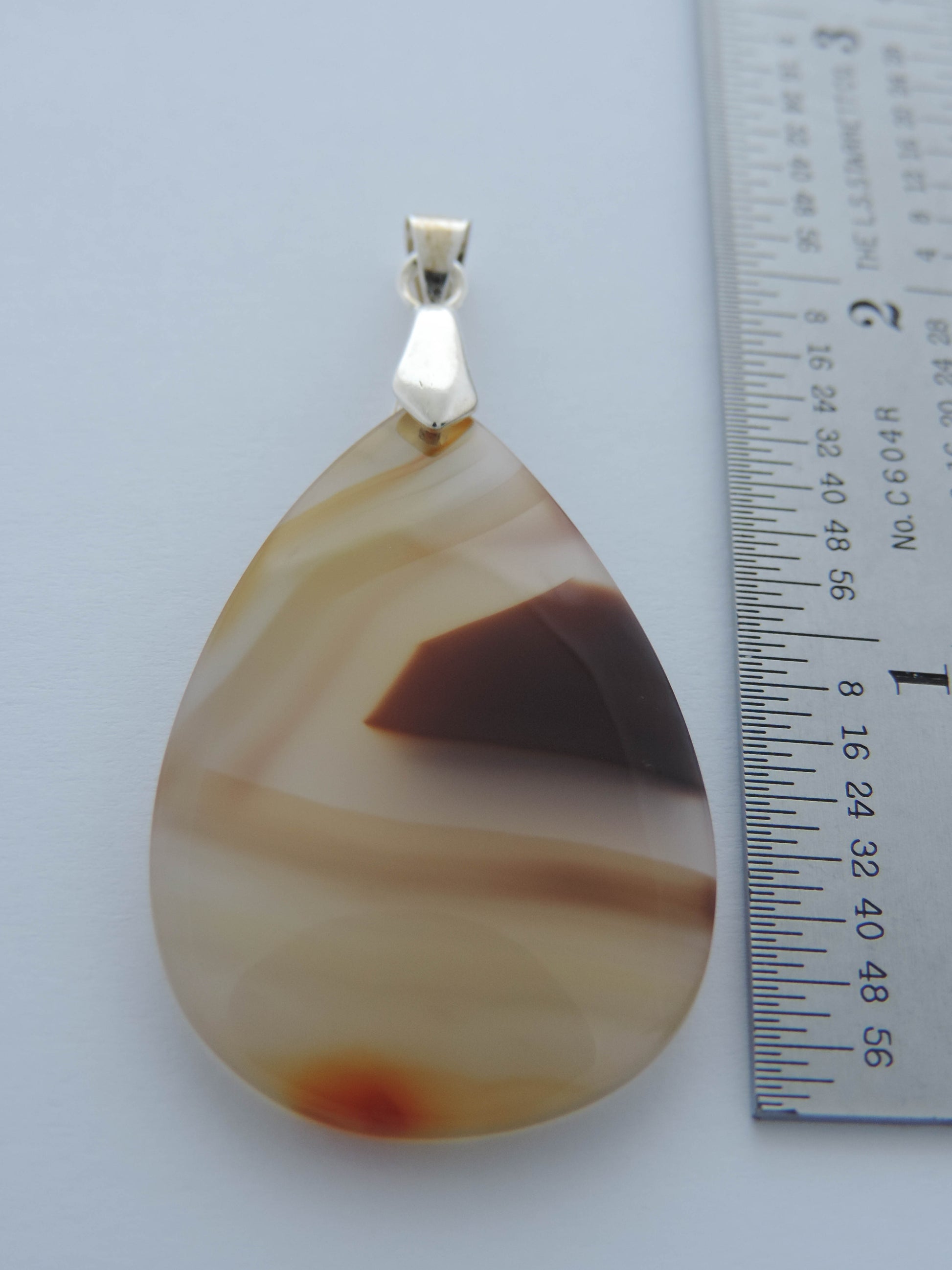 Our hand crafted jewelry pendant is photographed next to a ruler for size.