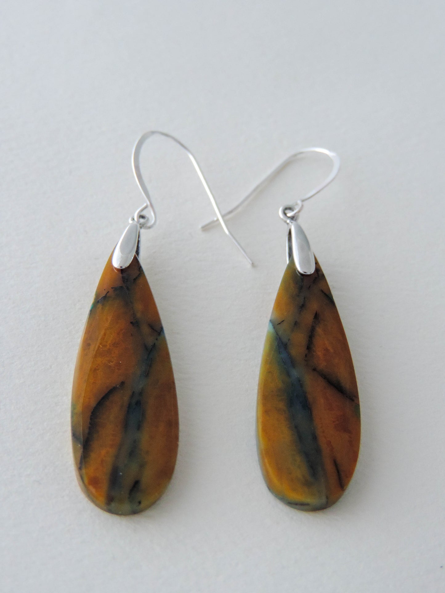 The bail and earring wires are authentic 925 sterling silver. Feel treasured when you wear these earrings! Extremely rare and lovely, Indonesian Blue Opalized Wood is a cherished material used by lapidary artists for creating stunning pieces of jewelry. The material was first found as pebbles and rounded stones in streams and near the slopes of three volcanoes in the West Java Province.