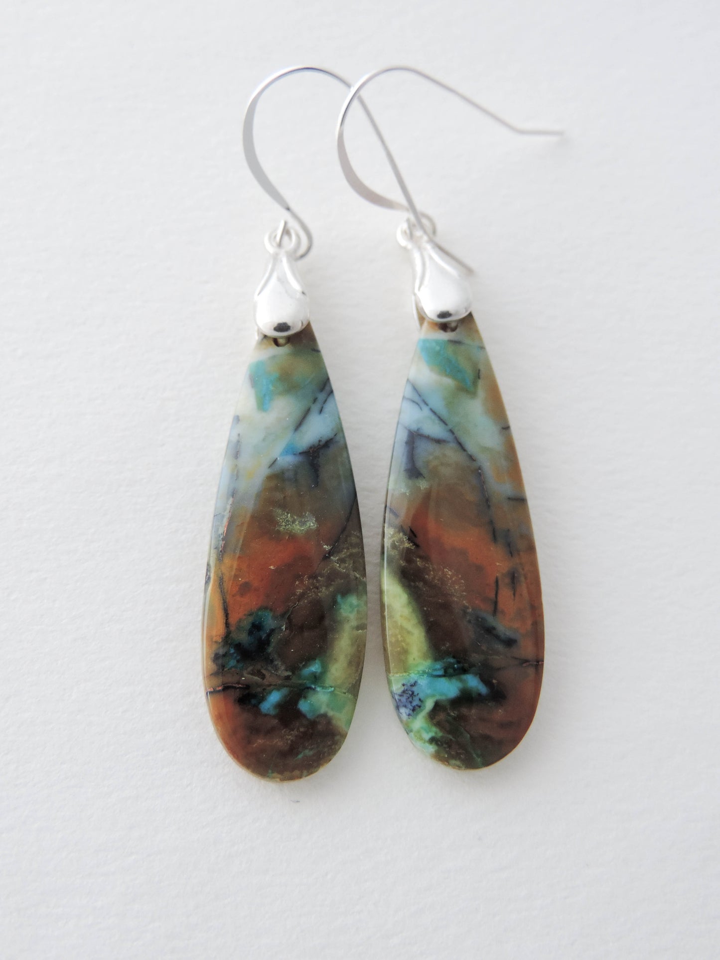 The bail and earring wires are authentic 925 sterling silver. Feel treasured when you wear these earrings!Extremely rare and lovely, Indonesian Blue Opalized Wood is a cherished material used by lapidary artists for creating stunning pieces of jewelry. The material was first found as pebbles and rounded stones in streams and near the slopes of three volcanoes in the West Java Province.