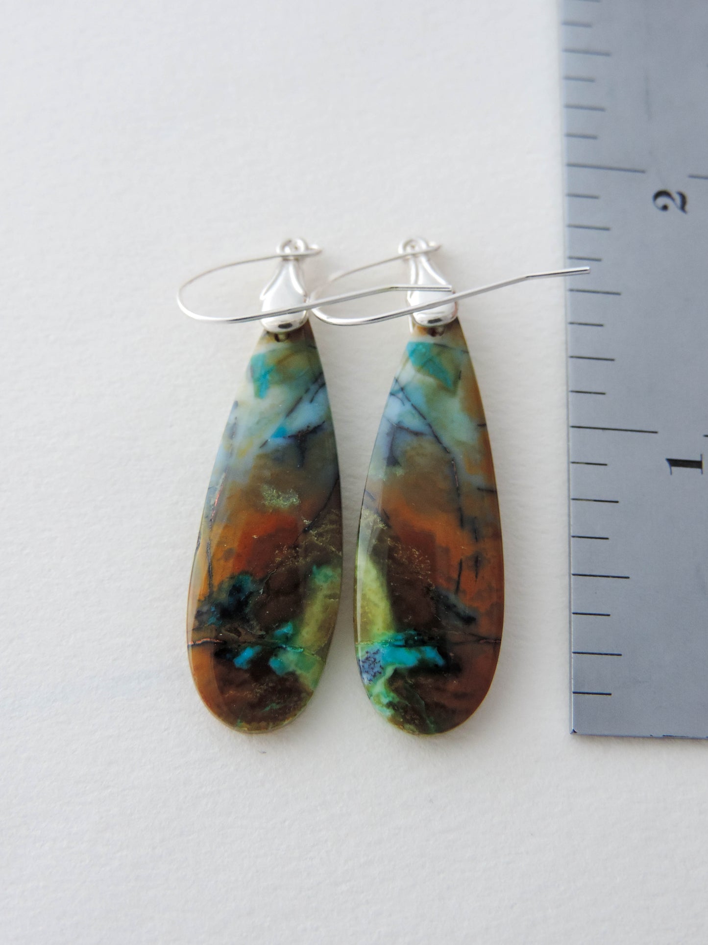 The bail and earring wires are authentic 925 sterling silver. Feel treasured when you wear these earrings!Extremely rare and lovely, Indonesian Blue Opalized Wood is a cherished material used by lapidary artists for creating stunning pieces of jewelry. The material was first found as pebbles and rounded stones in streams and near the slopes of three volcanoes in the West Java Province.