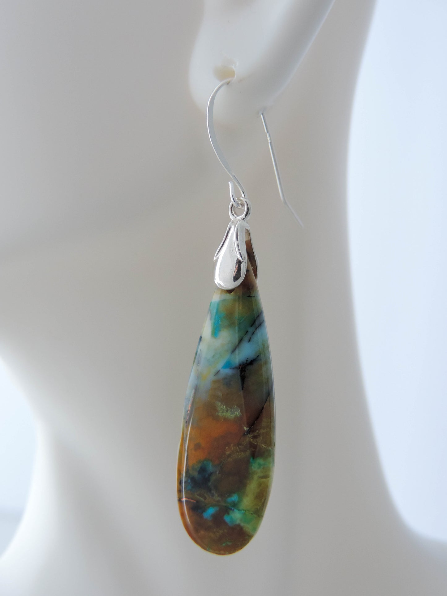 The bail and earring wires are authentic 925 sterling silver. Feel treasured when you wear these earrings!Extremely rare and lovely, Indonesian Blue Opalized Wood is a cherished material used by lapidary artists for creating stunning pieces of jewelry. The material was first found as pebbles and rounded stones in streams and near the slopes of three volcanoes in the West Java Province.