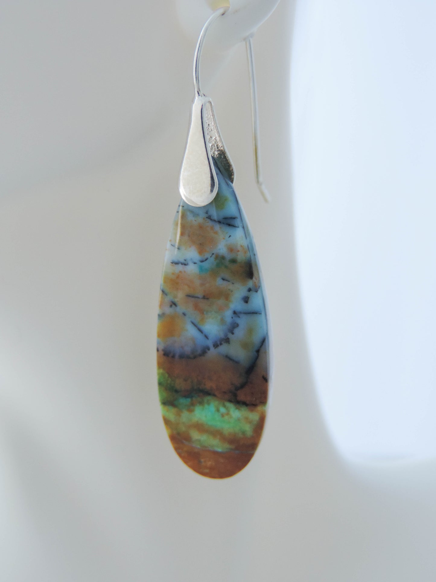 Extremely rare and lovely, Indonesian Blue Opalized Wood is a cherished material used by lapidary artists for creating stunning pieces of jewelry. The material was first found as pebbles and rounded stones in streams and near the slopes of three volcanoes in the West Java Province. The bail and earring wires are authentic 925 sterling silver. Feel treasured when you wear these earrings!