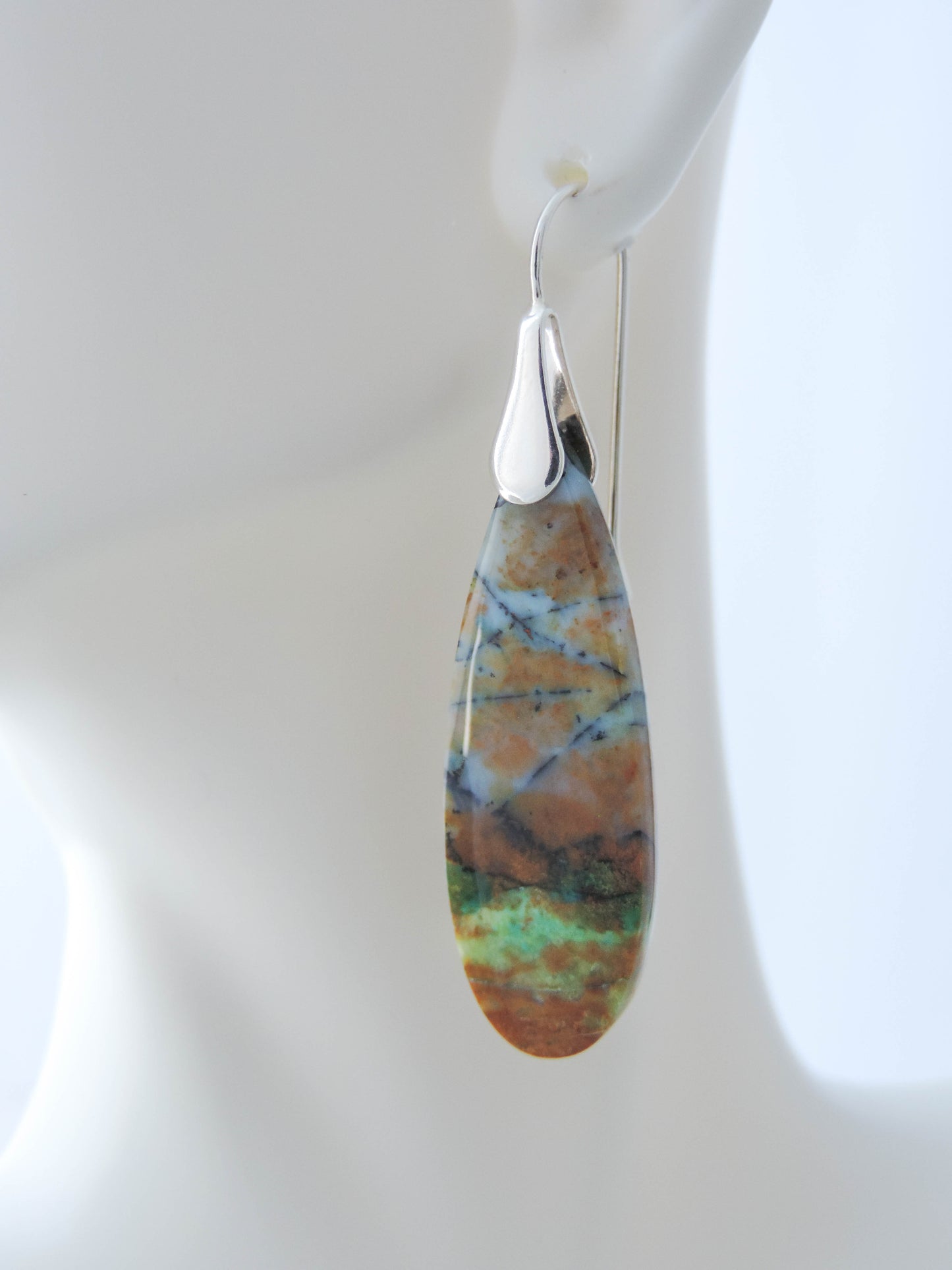 Extremely rare and lovely, Indonesian Blue Opalized Wood is a cherished material used by lapidary artists for creating stunning pieces of jewelry. The material was first found as pebbles and rounded stones in streams and near the slopes of three volcanoes in the West Java Province. The bail and earring wires are authentic 925 sterling silver. Feel treasured when you wear these earrings!