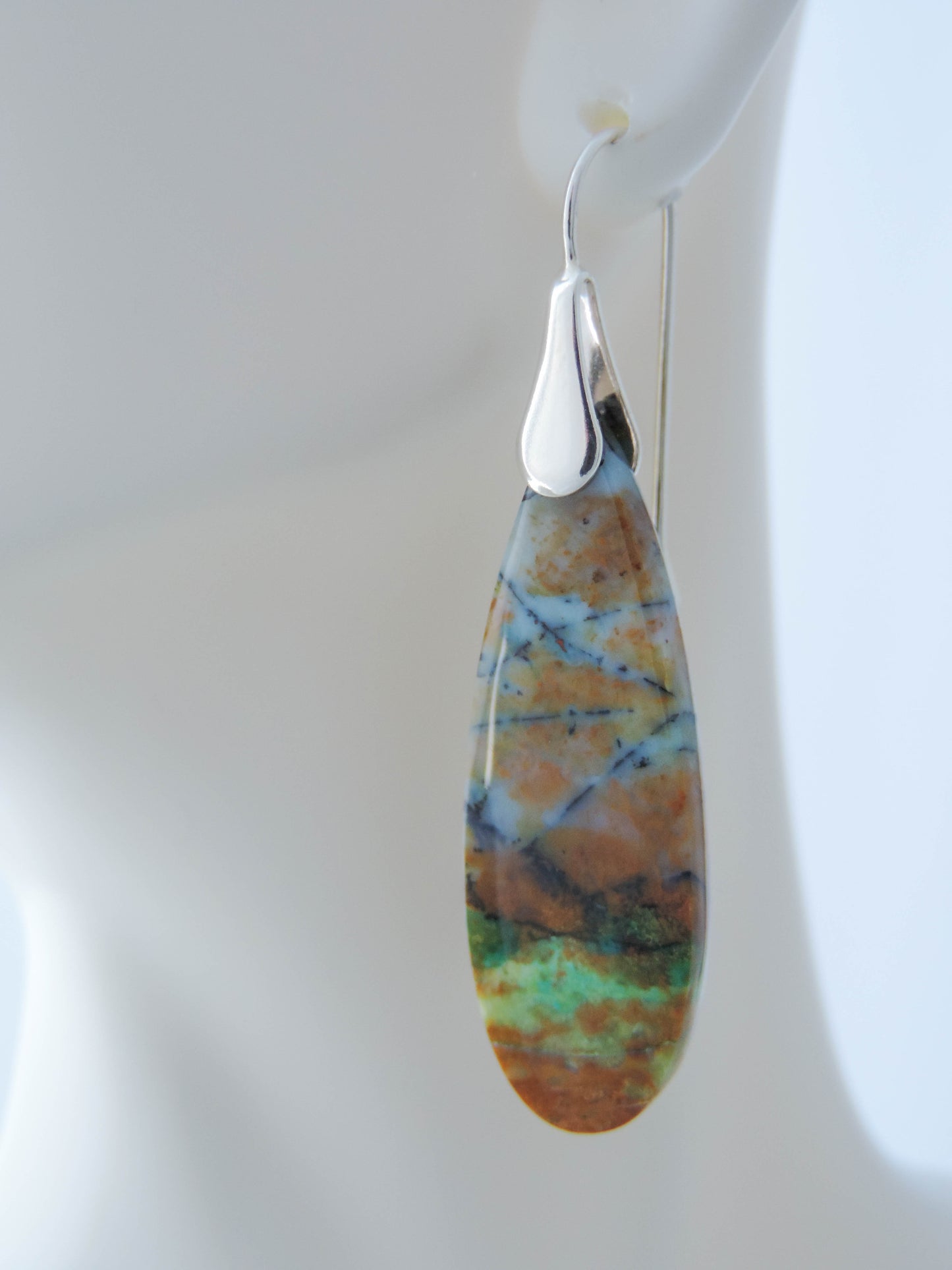 Extremely rare and lovely, Indonesian Blue Opalized Wood is a cherished material used by lapidary artists for creating stunning pieces of jewelry. The material was first found as pebbles and rounded stones in streams and near the slopes of three volcanoes in the West Java Province. The bail and earring wires are authentic 925 sterling silver. Feel treasured when you wear these earrings!