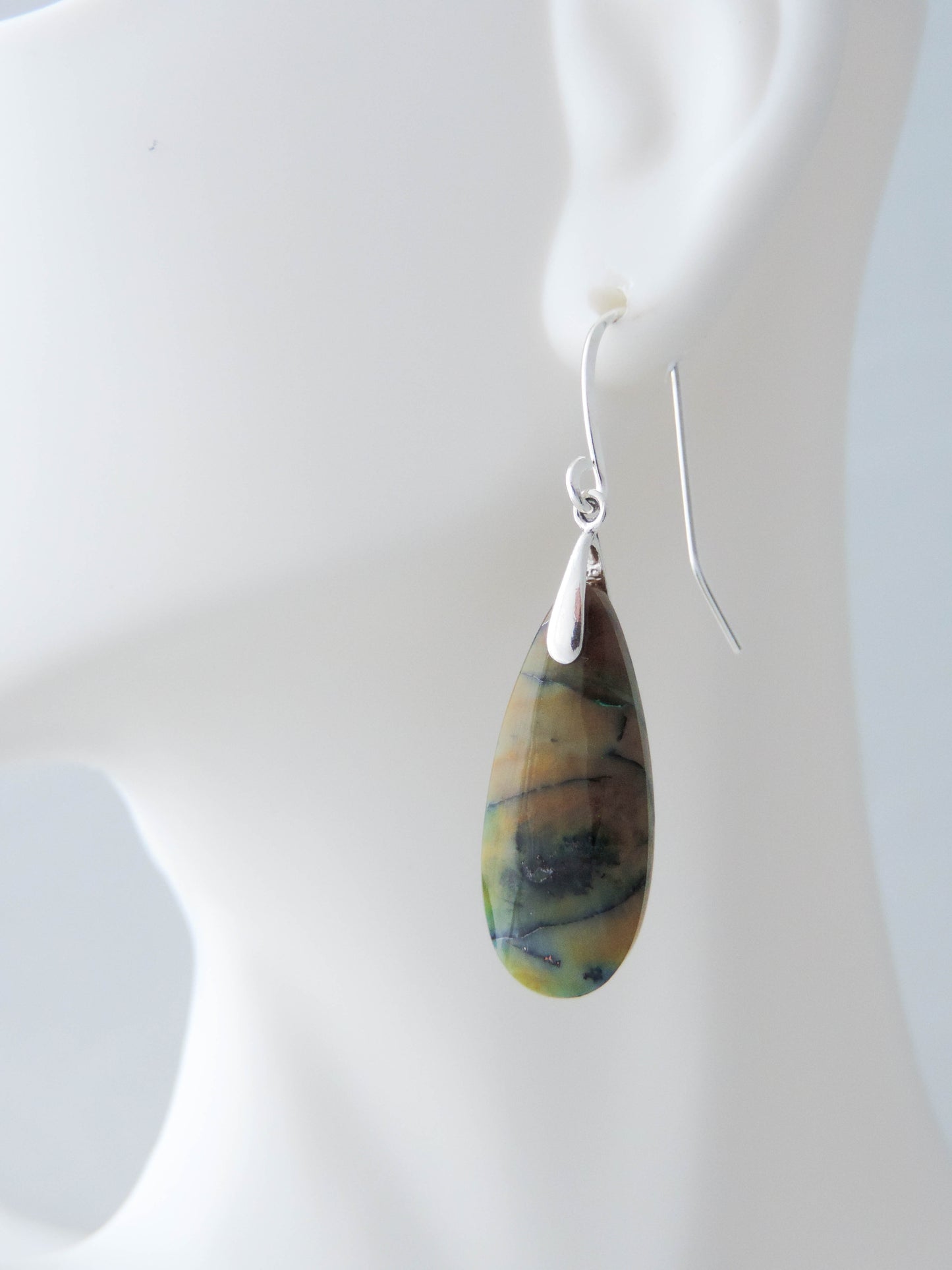 Extremely rare and lovely, Indonesian Blue Opalized Wood is a cherished material used by lapidary artists for creating stunning pieces of jewelry. The material was first found as pebbles and rounded stones in streams and near the slopes of three volcanoes in the West Java Province. The bail and earring wires are authentic 925 sterling silver. Feel treasured when you wear these earrings!
