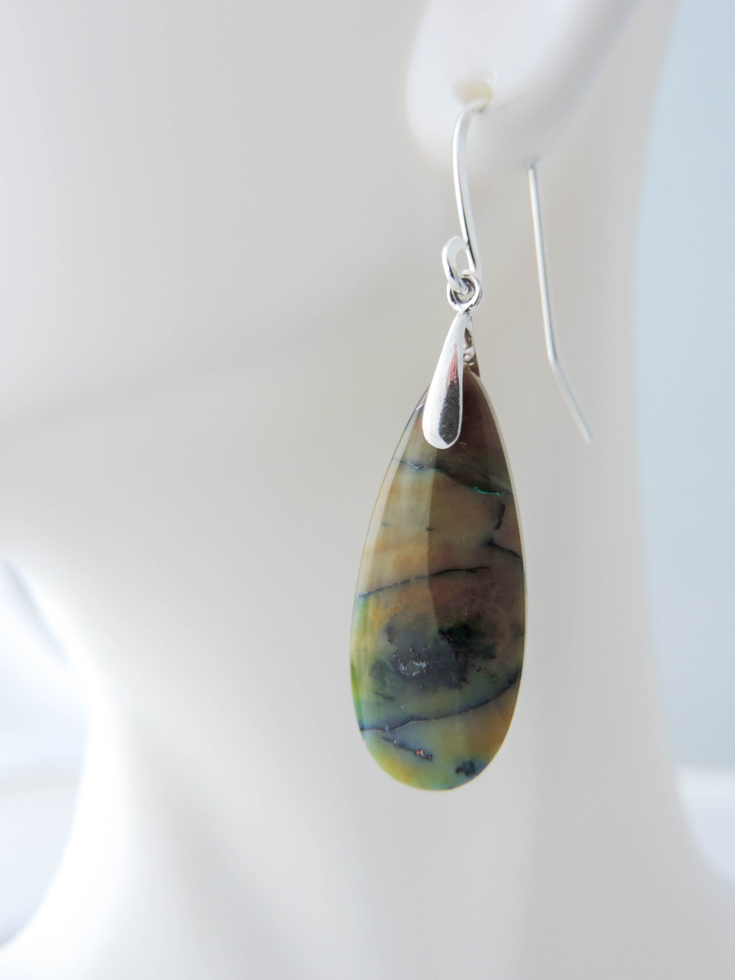 Extremely rare and lovely, Indonesian Blue Opalized Wood is a cherished material used by lapidary artists for creating stunning pieces of jewelry. The material was first found as pebbles and rounded stones in streams and near the slopes of three volcanoes in the West Java Province. The bail and earring wires are authentic 925 sterling silver. Feel treasured when you wear these earrings!