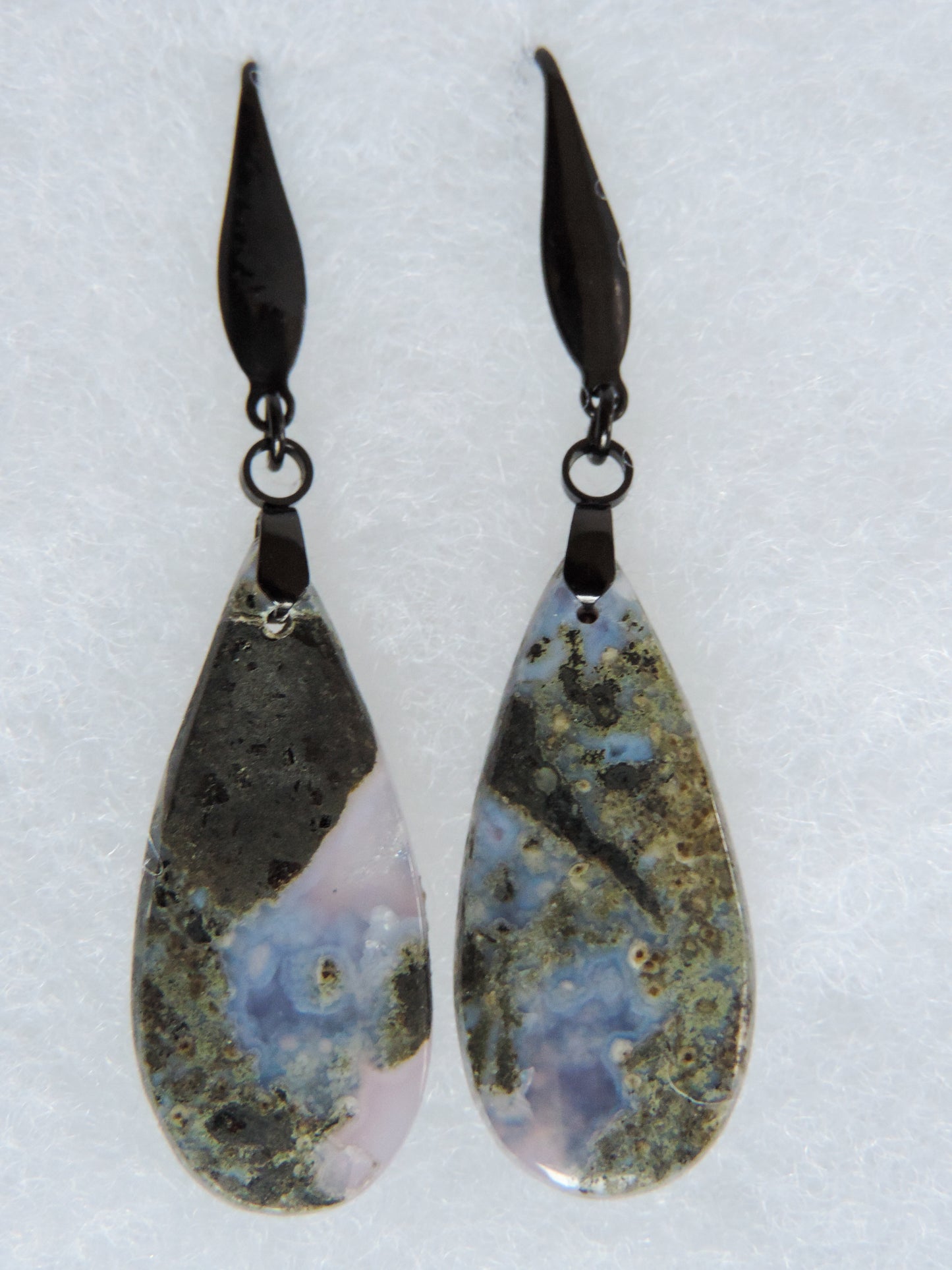 Purple Moss Agate Earrings. Purple gemstones hold significant and powerful spiritual qualities. Purple has been associated with wealth, passion, ambition, magic, awareness, mystery, tranquility, inspiration, understanding, calmness and wisdom to name a few. Throughout history, the spiritual meanings and properties of purple gemstones have always been positive as they were known to bring forth the purest aspirations of human kind.