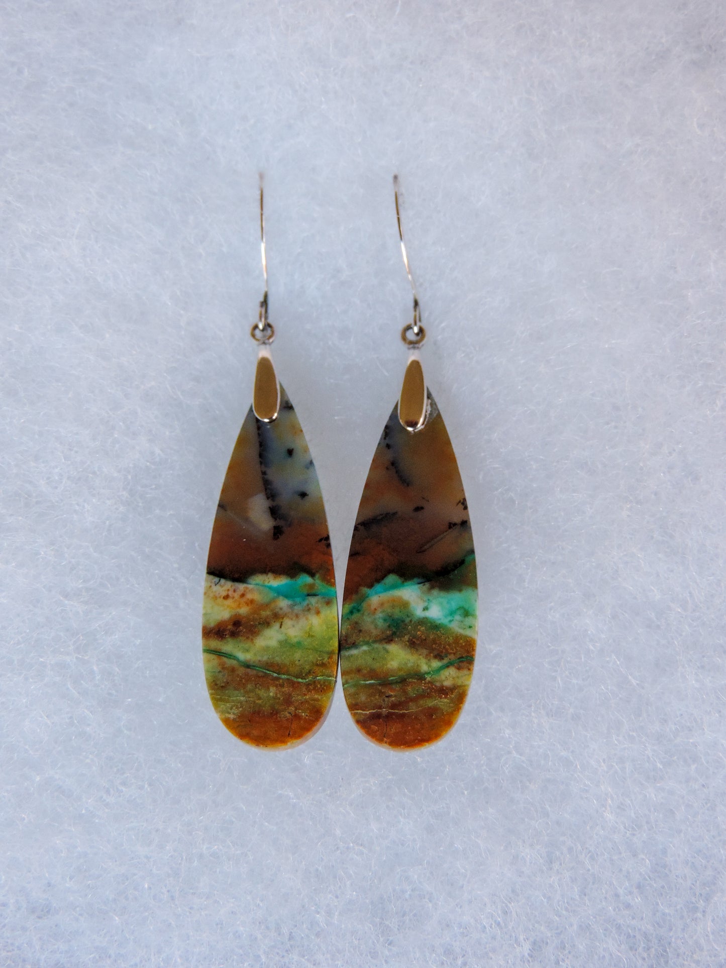 These rich minerals are responsible for the amazing colors in the stone. The bail and earring wires are authentic 925 sterling silver.
