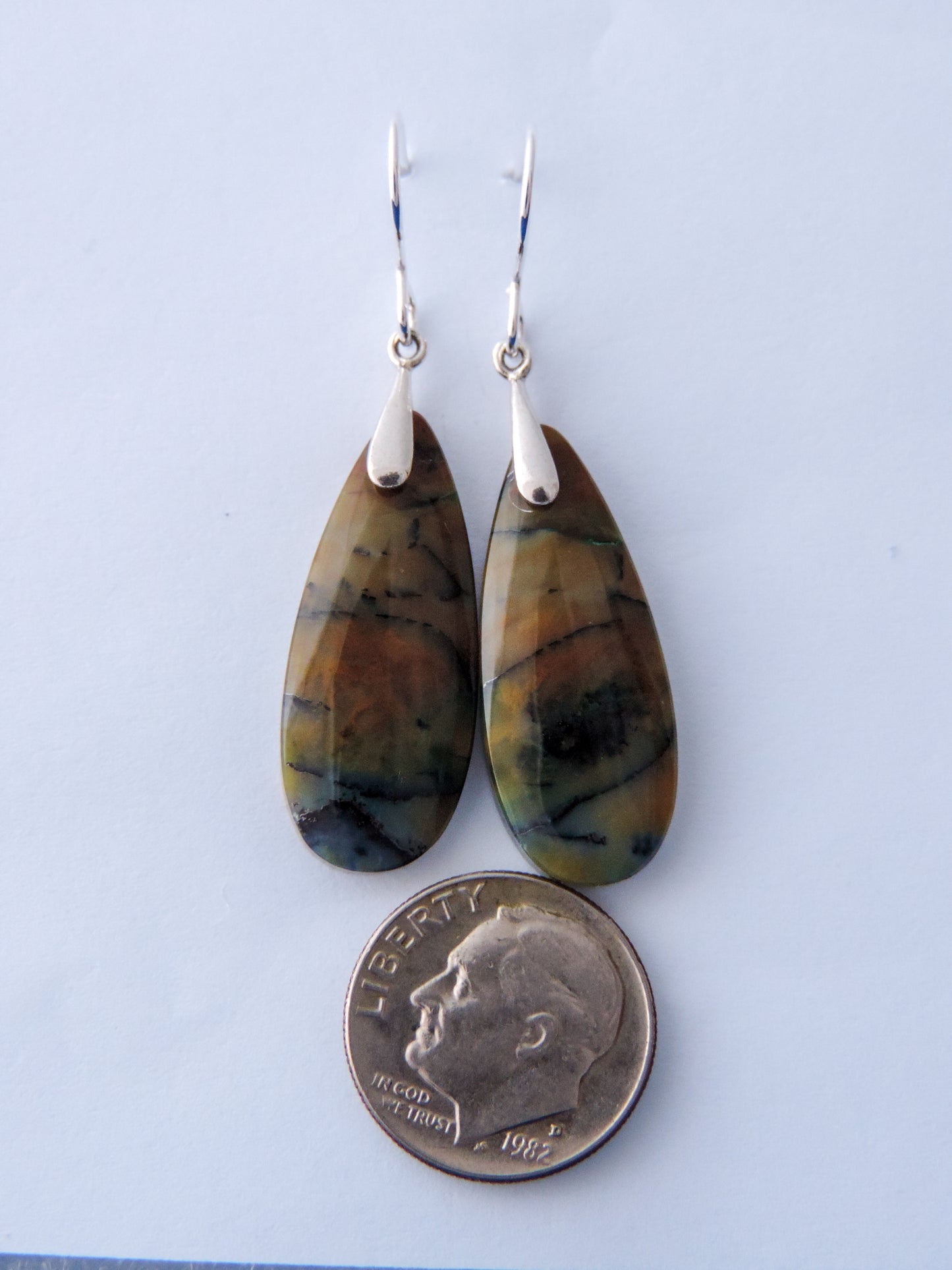 Extremely rare and lovely, Indonesian Blue Opalized Wood is a cherished material used by lapidary artists for creating stunning pieces of jewelry. The material was first found as pebbles and rounded stones in streams and near the slopes of three volcanoes in the West Java Province. The bail and earring wires are authentic 925 sterling silver. Feel treasured when you wear these earrings!