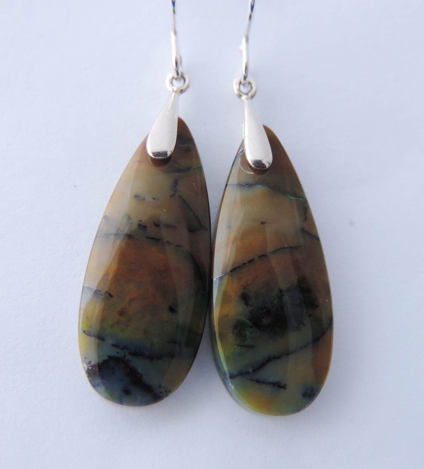 Extremely rare and lovely, Indonesian Blue Opalized Wood is a cherished material used by lapidary artists for creating stunning pieces of jewelry. The material was first found as pebbles and rounded stones in streams and near the slopes of three volcanoes in the West Java Province. The bail and earring wires are authentic 925 sterling silver. Feel treasured when you wear these earrings!