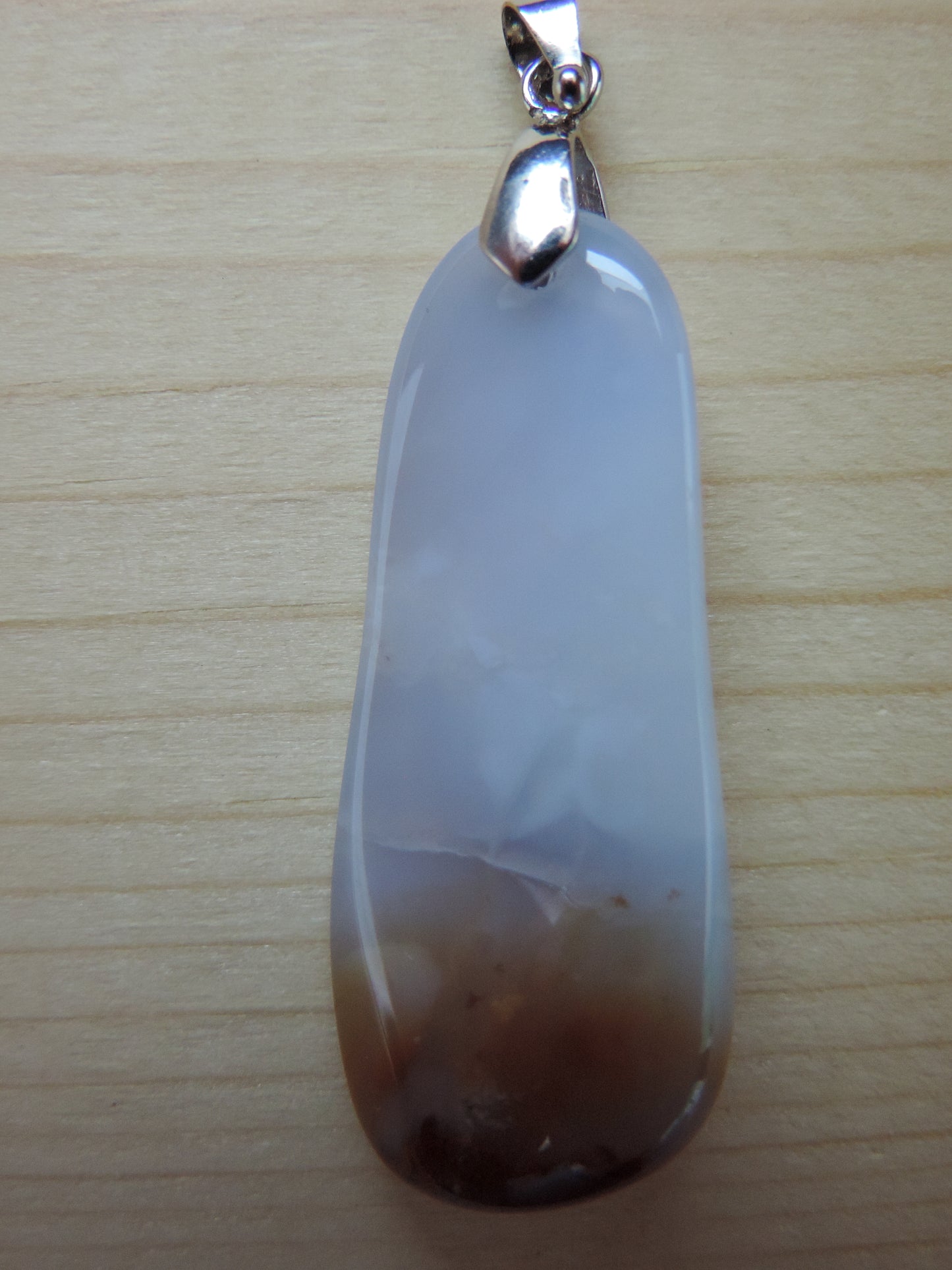 Montana Madison Blue Agate Pendant. The stone in this pendant is a unique result of tumble shaping and polishing a piece of agate from its natural state. The pendant is reversible, allowing you to present its natural beauty from either side to be admired by all. This one of a kind pendant will show off your unique taste!