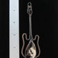 Indonesian Palm Root & Mixed Metals Guitar Pendant.   Petrified Palm Root comes from the fossilized root system of Indonesian palm trees.  Chalcedony Quartz and Jasper gradually replaced the root wood over millions of years, resulting in a unique material that typically doesn’t have the visible fiber pattern of the tree section but will often have a variety of swirls and colors.  Like other fossilized materials,