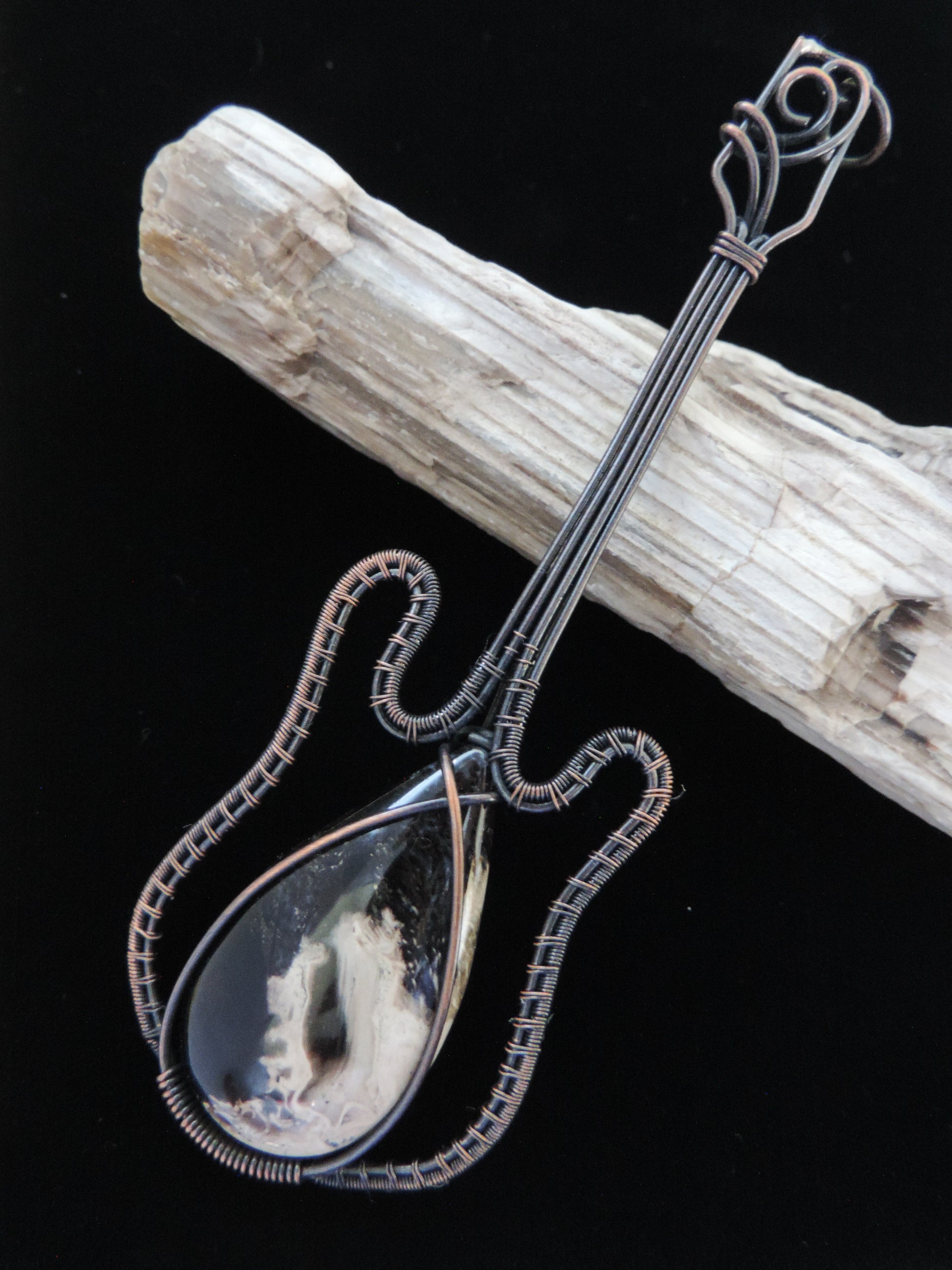 Show off your unique taste with this palm root guitar pendant!