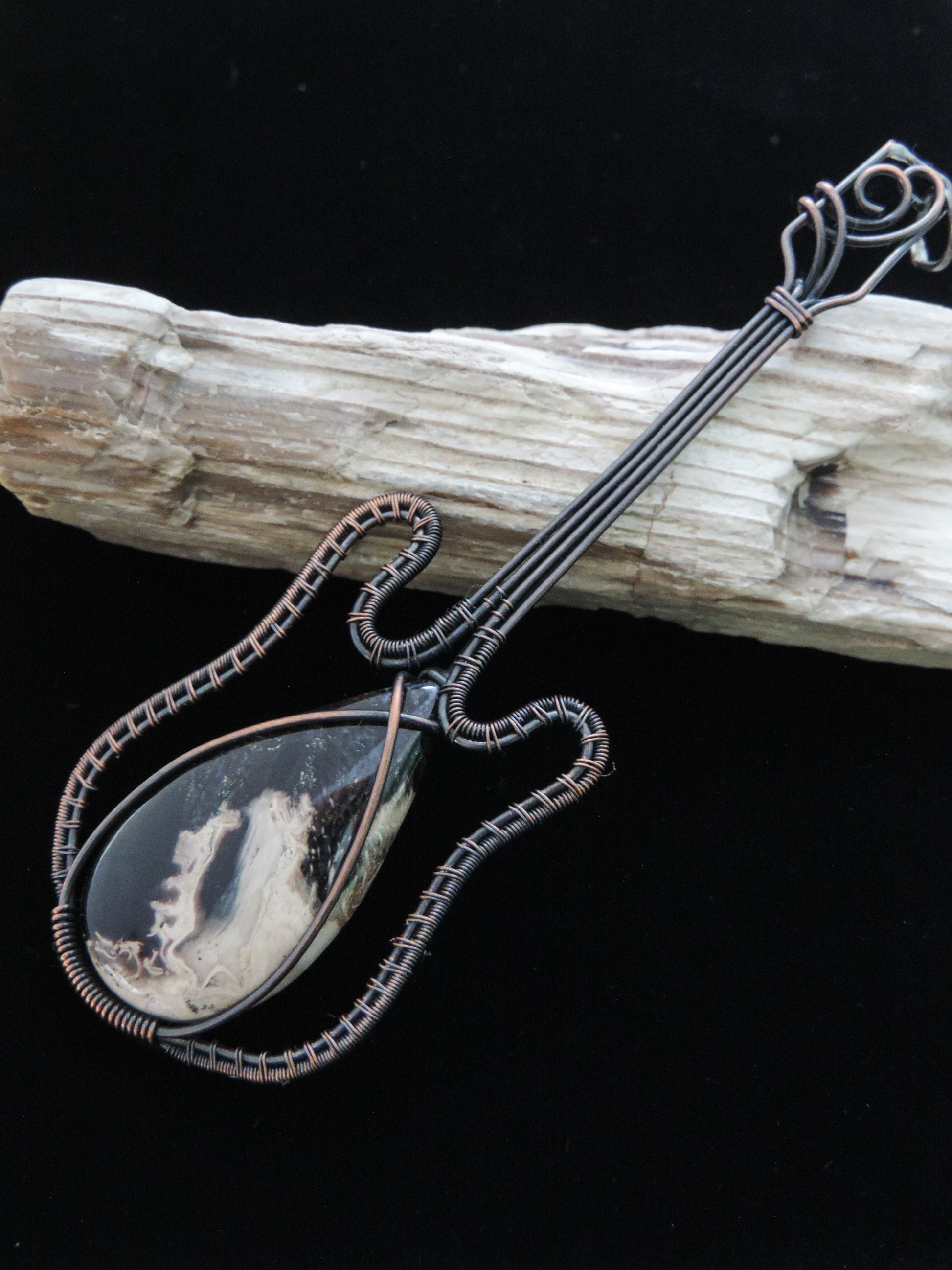 Like other fossilized materials, petrified Palm Root represents one of the many wonders of ancient Earth!    Show off your unique taste with this palm root guitar pendant!