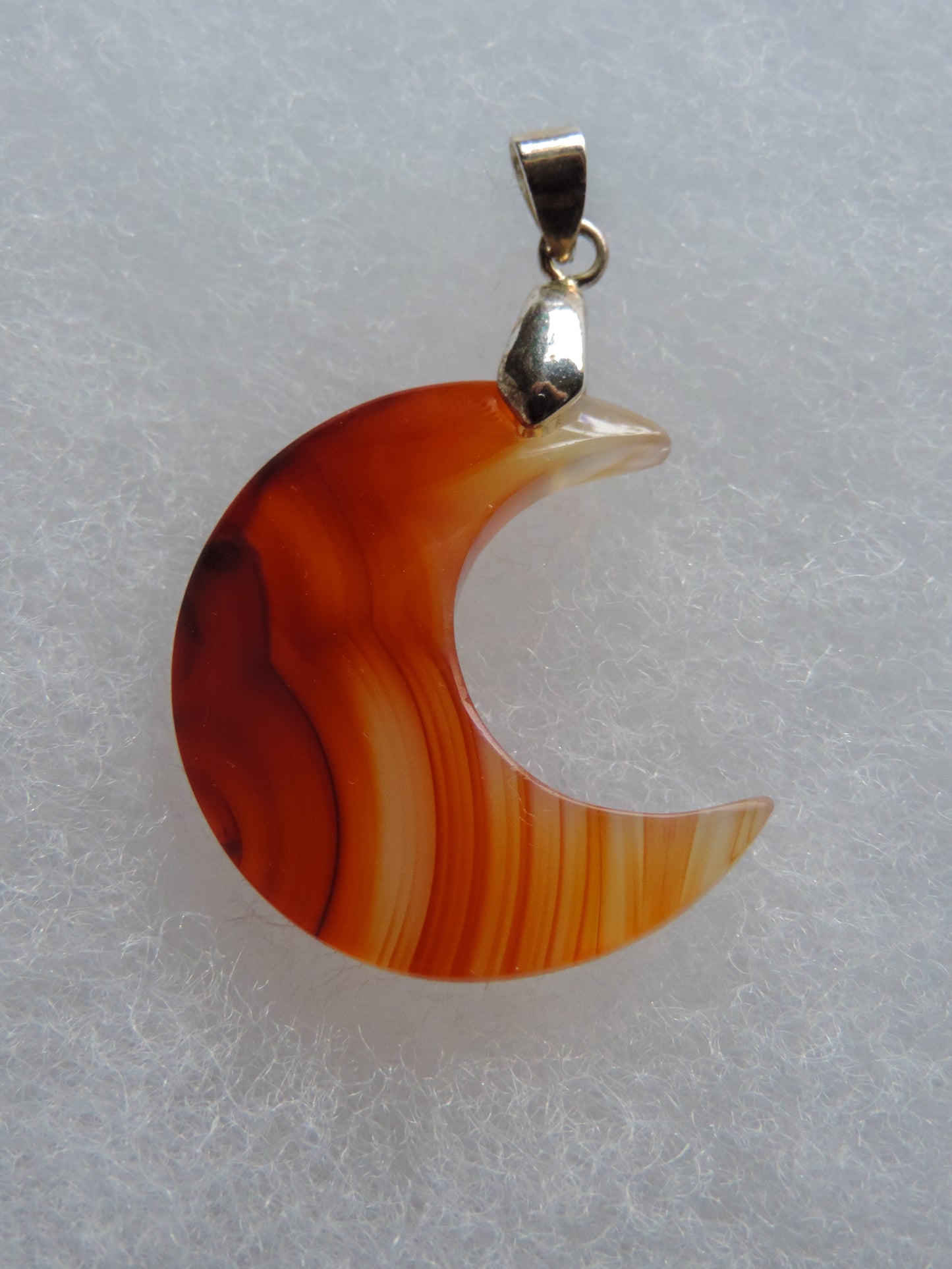 Carnelian Moon Pendant.  Indonesian Agates exhibit a wide variety of colors and amazing complexity.  No two agates are exactly alike, each one being a unique and beautiful creation!  Agates with multiple bands of color are known as fortification agates, those with dendritic or moss looking inclusions are referred to as moss agate and many others are given descriptive names relative to their appearance or where they are found. 