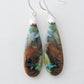 The bail and earring wires are authentic 925 sterling silver.  Feel treasured when you wear these earrings!Extremely rare and lovely, Indonesian Blue Opalized Wood is a cherished material used by lapidary artists for creating stunning pieces of jewelry.  The material was first found as pebbles and rounded stones in streams and near the slopes of three volcanoes in the West Java Province.  