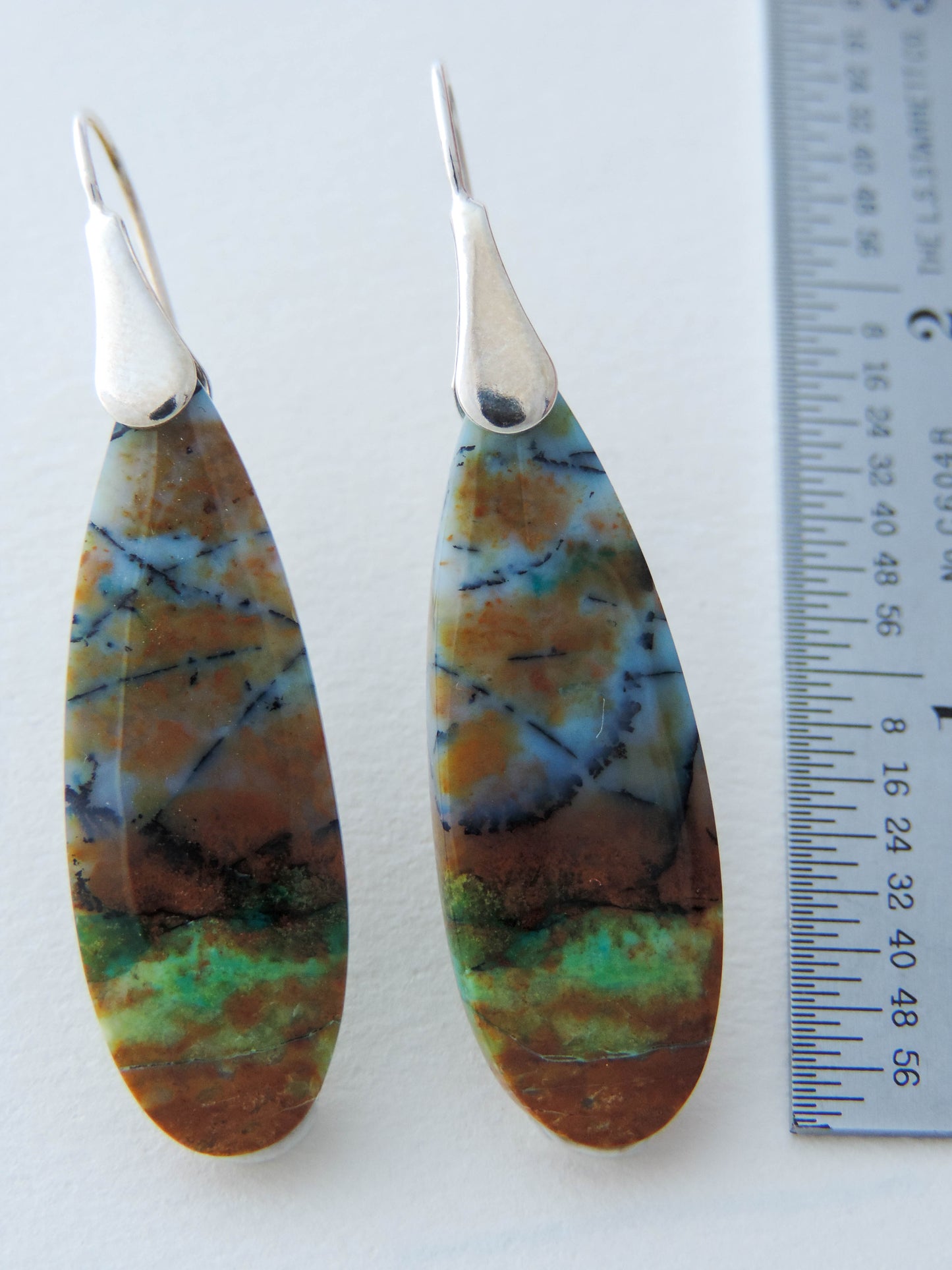 Extremely rare and lovely, Indonesian Blue Opalized Wood is a cherished material used by lapidary artists for creating stunning pieces of jewelry.  The material was first found as pebbles and rounded stones in streams and near the slopes of three volcanoes in the West Java Province. The bail and earring wires are authentic 925 sterling silver.  Feel treasured when you wear these earrings!