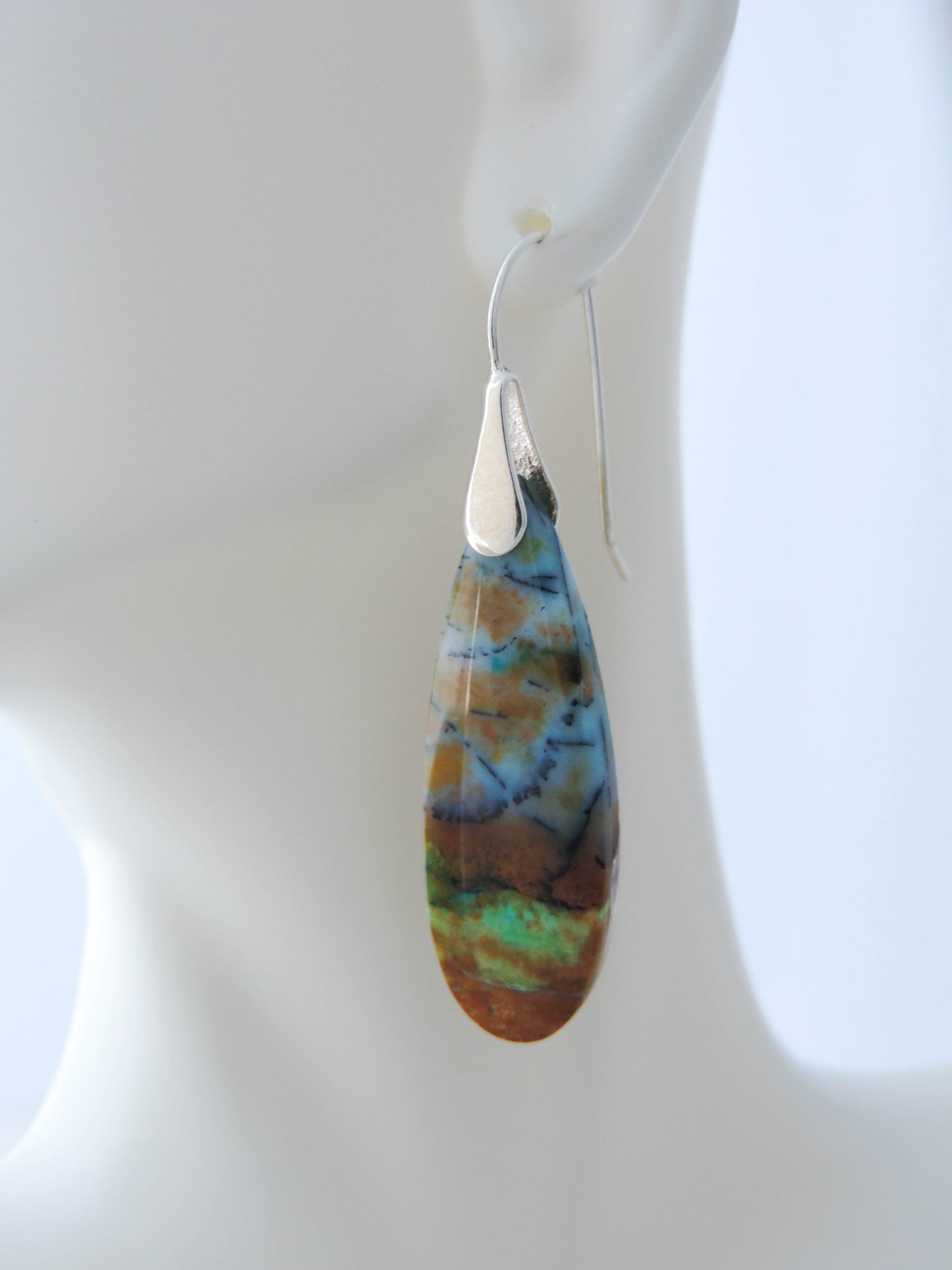 Extremely rare and lovely, Indonesian Blue Opalized Wood is a cherished material used by lapidary artists for creating stunning pieces of jewelry.  The material was first found as pebbles and rounded stones in streams and near the slopes of three volcanoes in the West Java Province. The bail and earring wires are authentic 925 sterling silver.  Feel treasured when you wear these earrings!