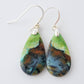 Extremely rare and lovely, Indonesian Blue Opalized Wood is a cherished material used by lapidary artists for creating stunning pieces of jewelry.  The material was first found as pebbles and rounded stones in streams and near the slopes of three volcanoes in the West Java Province.  The bail and earring wires are authentic 925 sterling silver.  Feel treasured when you wear these earrings!