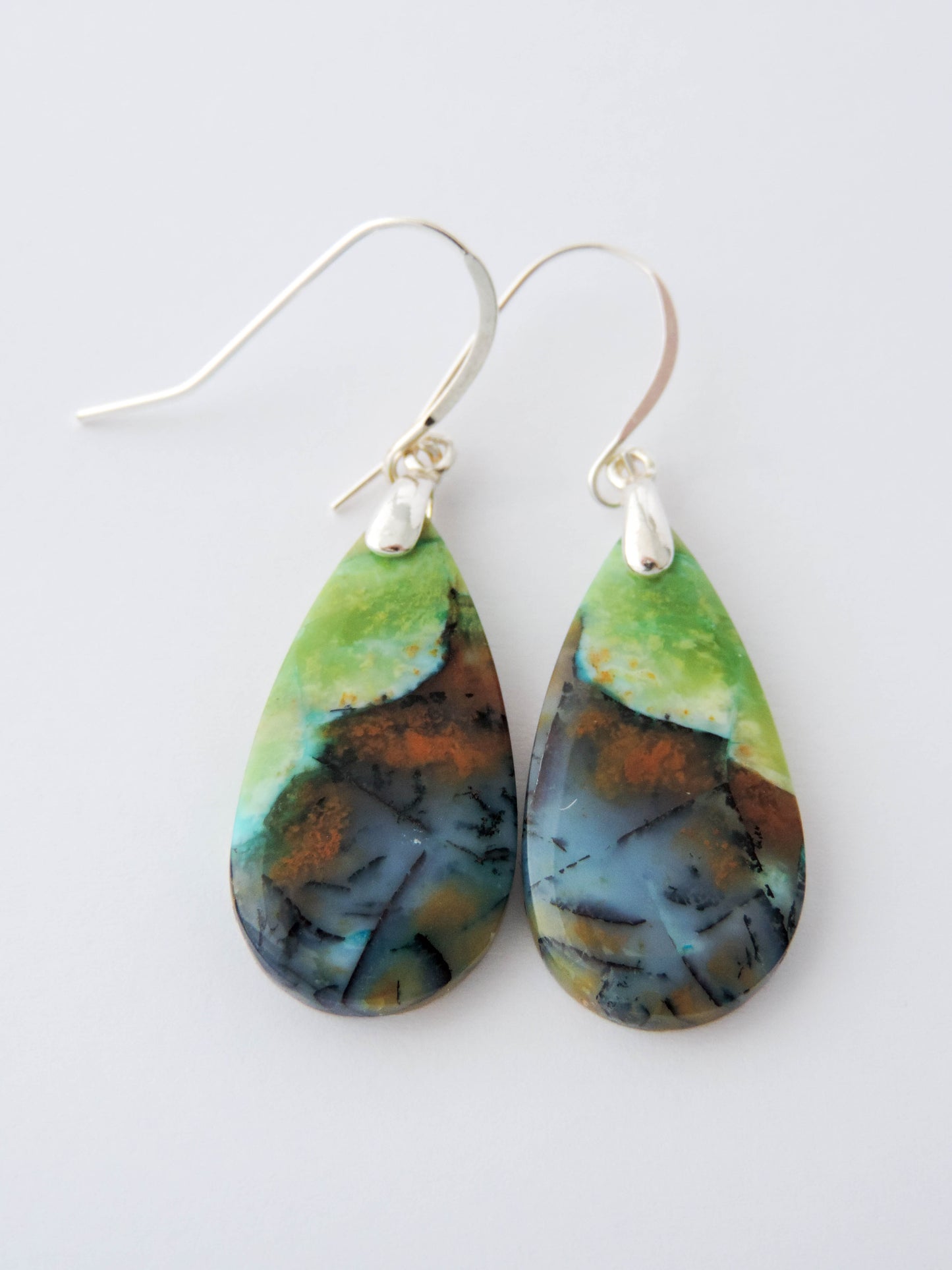 Extremely rare and lovely, Indonesian Blue Opalized Wood is a cherished material used by lapidary artists for creating stunning pieces of jewelry.  The material was first found as pebbles and rounded stones in streams and near the slopes of three volcanoes in the West Java Province.  The bail and earring wires are authentic 925 sterling silver.  Feel treasured when you wear these earrings!