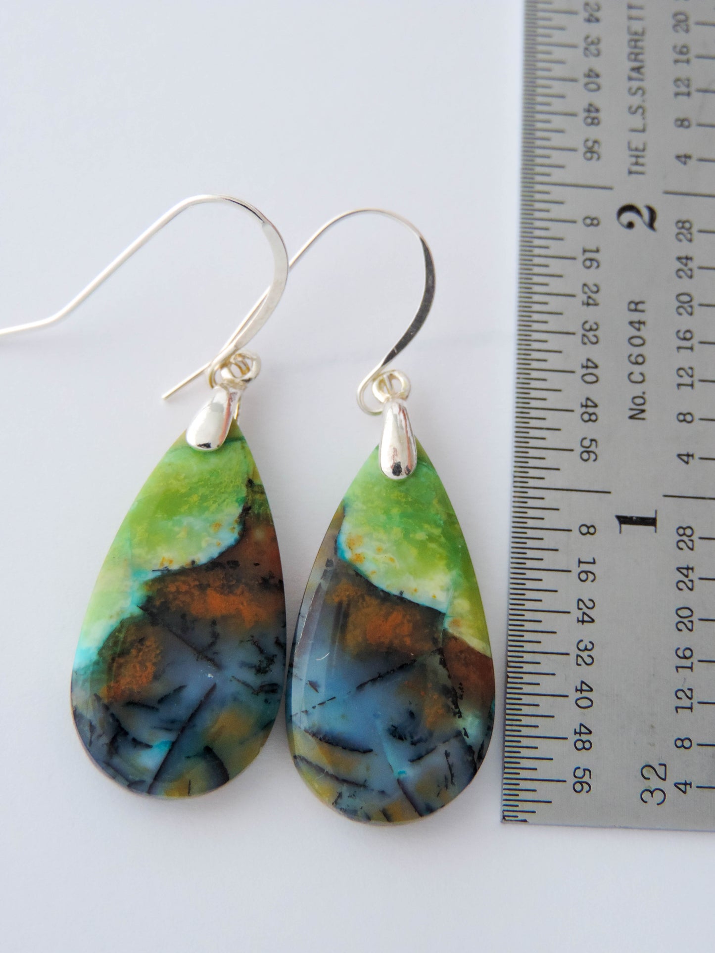 Extremely rare and lovely, Indonesian Blue Opalized Wood is a cherished material used by lapidary artists for creating stunning pieces of jewelry.  The material was first found as pebbles and rounded stones in streams and near the slopes of three volcanoes in the West Java Province.  The bail and earring wires are authentic 925 sterling silver.  Feel treasured when you wear these earrings!