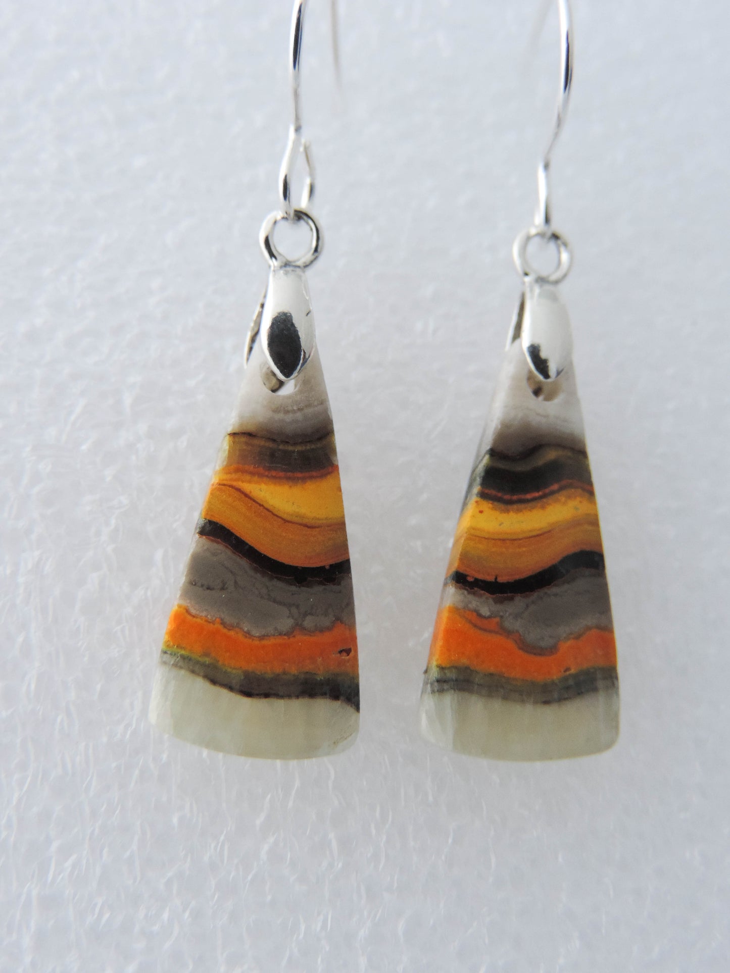 Bumblebee Jasper is named for its yellow, white, orange and black colored banding which resembles a common bumblebee.  This mineral was discovered in the Papandayan Volcano, West Java Province, Indonesia.  The gemstone is truly unique in appearance, fun to wear and is known spiritually for its uplifting, radiant energy.  Bee the buzz when you wear these fun earrings!  The bail and earring wire are authentic 925 sterling silver.