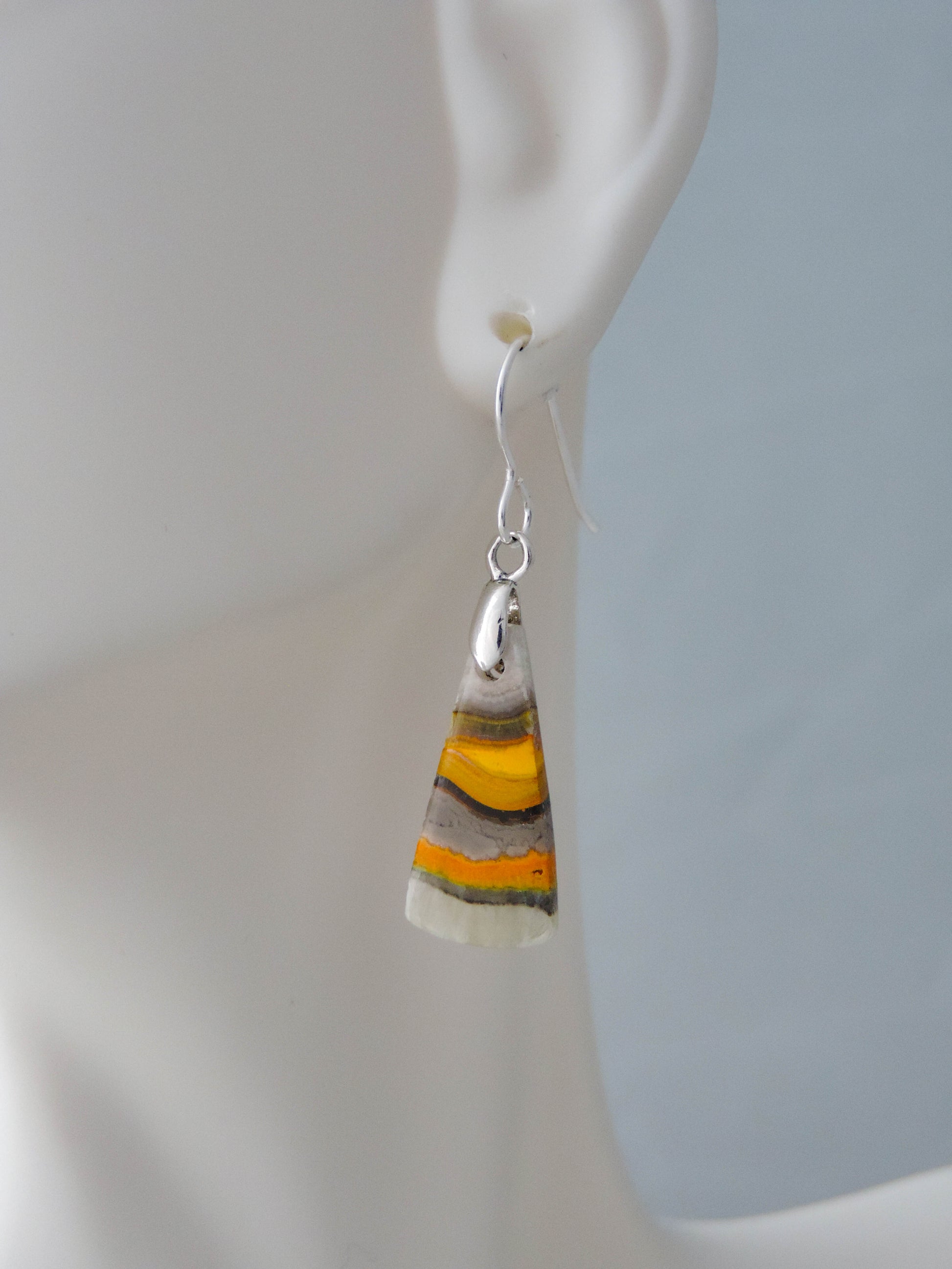 Bumblebee Jasper is named for its yellow, white, orange and black colored banding which resembles a common bumblebee.  This mineral was discovered in the Papandayan Volcano, West Java Province, Indonesia.  The gemstone is truly unique in appearance, fun to wear and is known spiritually for its uplifting, radiant energy.  Bee the buzz when you wear these fun earrings!  The bail and earring wire are authentic 925 sterling silver.