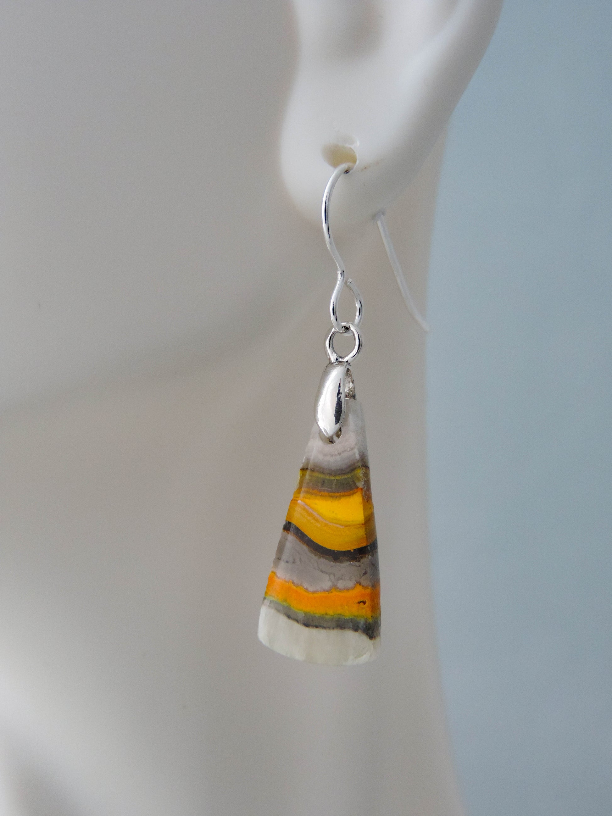 Bumblebee Jasper is named for its yellow, white, orange and black colored banding which resembles a common bumblebee.  This mineral was discovered in the Papandayan Volcano, West Java Province, Indonesia.  The gemstone is truly unique in appearance, fun to wear and is known spiritually for its uplifting, radiant energy.  Bee the buzz when you wear these fun earrings!  The bail and earring wire are authentic 925 sterling silver.