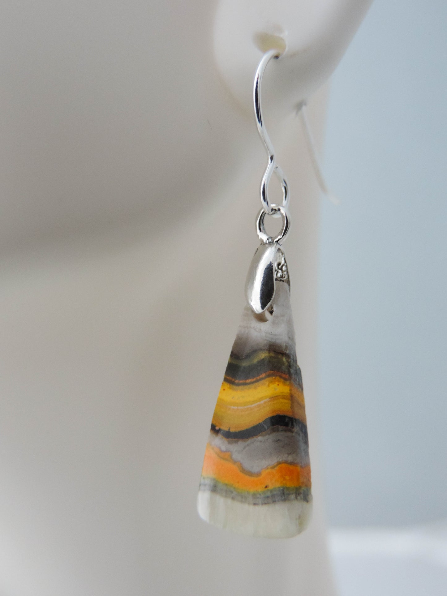 Bumblebee Jasper is named for its yellow, white, orange and black colored banding which resembles a common bumblebee.  This mineral was discovered in the Papandayan Volcano, West Java Province, Indonesia.  The gemstone is truly unique in appearance, fun to wear and is known spiritually for its uplifting, radiant energy.  Bee the buzz when you wear these fun earrings!  The bail and earring wire are authentic 925 sterling silver.