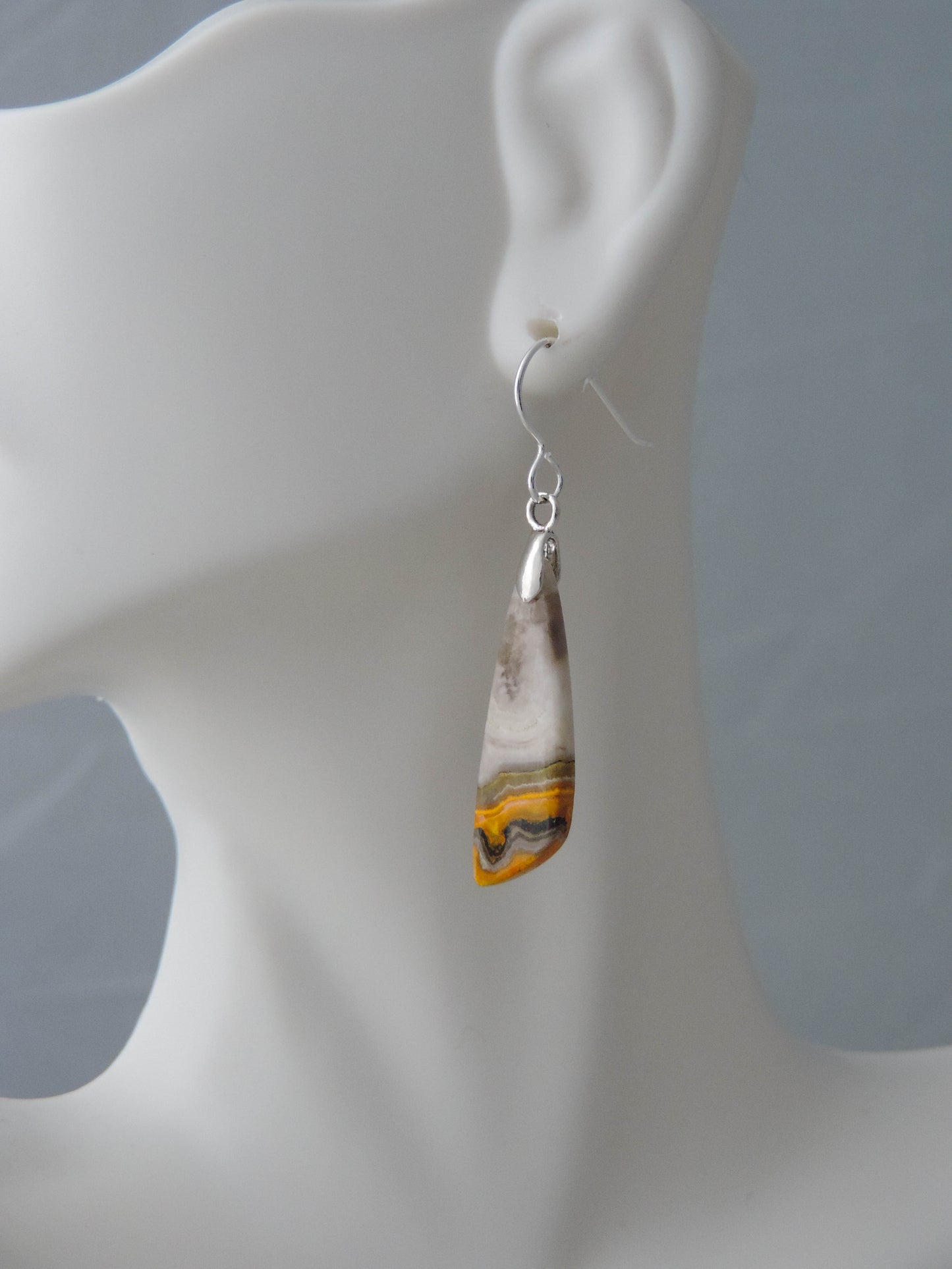 Bumblebee Jasper is named for its yellow, white, orange and black colored banding which resembles a common bumblebee.  This mineral was discovered in the Papandayan Volcano, West Java Province, Indonesia.  The gemstone is truly unique in appearance, fun to wear and is known spiritually for its uplifting, radiant energy.  Bee the buzz when you wear these fun earrings!  The bail and earring wire are authentic 925 sterling silver.