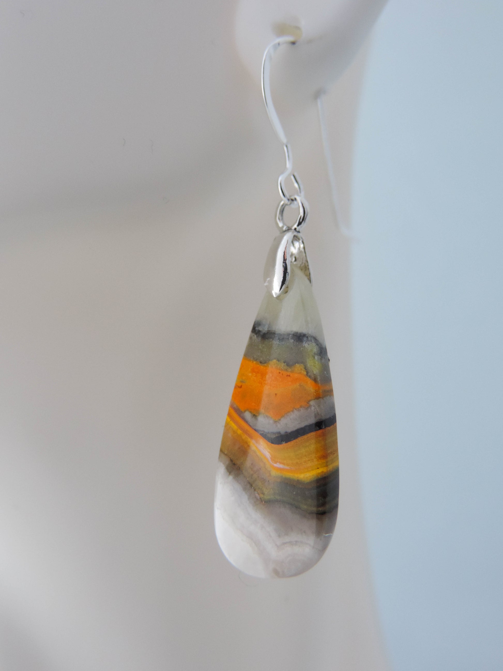 Bumblebee Jasper is named for its yellow, white, orange and black colored banding which resembles a common bumblebee.  This mineral was discovered in the Papandayan Volcano, West Java Province, Indonesia.  The gemstone is truly unique in appearance, fun to wear and is known spiritually for its uplifting, radiant energy.  Bee the buzz when you wear these fun earrings!  The bail and earring wire are authentic 925 sterling silver.