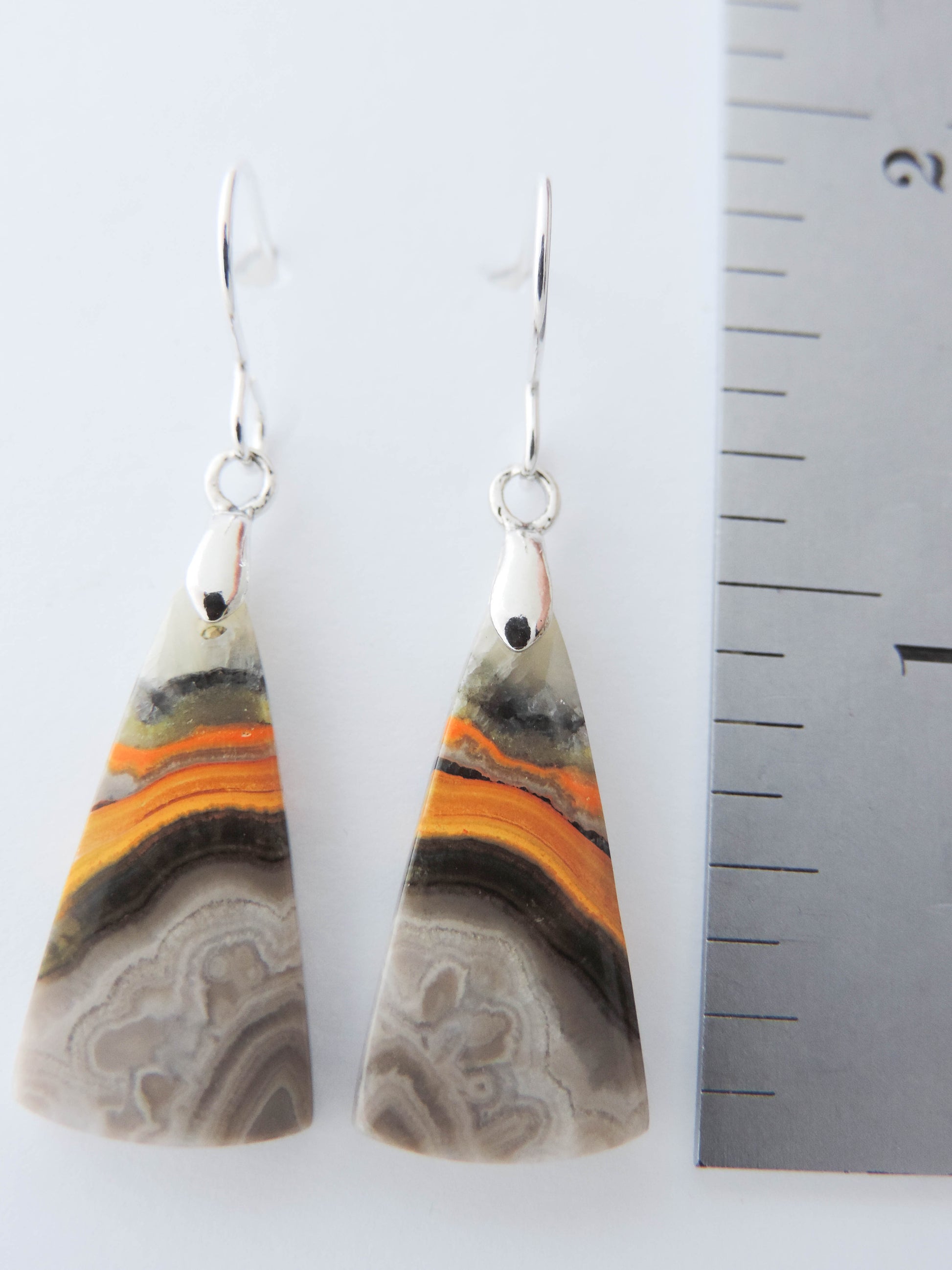 Bumblebee Jasper is named for its yellow, white, orange and black colored banding which resembles a common bumblebee.  This mineral was discovered in the Papandayan Volcano, West Java Province, Indonesia.  The gemstone is truly unique in appearance, fun to wear and is known spiritually for its uplifting, radiant energy.  Bee the buzz when you wear these fun earrings!  The bail and earring wire are authentic 925 sterling silver.