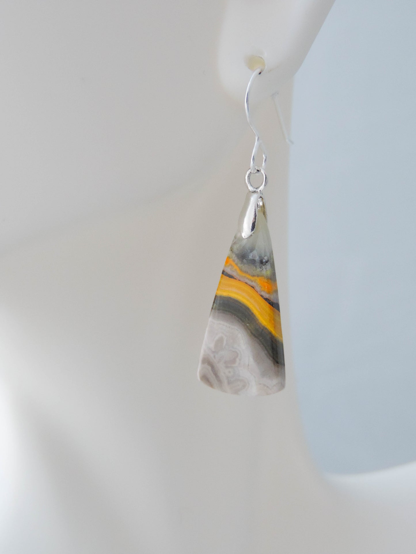 Bumblebee Jasper is named for its yellow, white, orange and black colored banding which resembles a common bumblebee.  This mineral was discovered in the Papandayan Volcano, West Java Province, Indonesia.  The gemstone is truly unique in appearance, fun to wear and is known spiritually for its uplifting, radiant energy.  Bee the buzz when you wear these fun earrings!  The bail and earring wire are authentic 925 sterling silver.