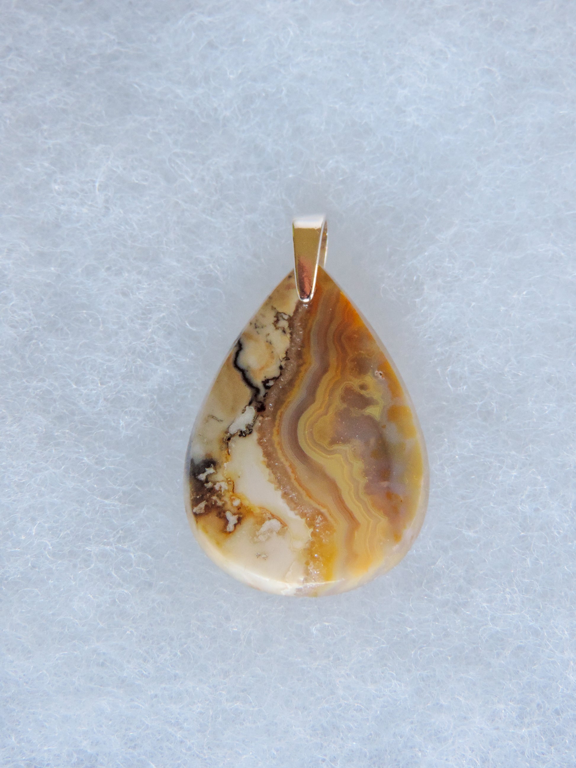 Brown Lace Agate Pendant.  Indonesian Agates exhibit a wide variety of colors and amazing complexity.  No two agates are exactly alike, each one being a unique and beautiful creation!  Agates with multiple bands of color are known as fortification agates, those with dendritic or moss looking inclusions are referred to as moss agate and many others are given descriptive names relative to their appearance or where they are found.  The