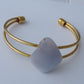 The translucent blue agate and its spectacular color variations have an alluring effect, many people find the stone naturally relaxing.  Original and unique in design, each piece is hand crafted by lapidary artists in Montana.      Our hand crafted jewelry is photographed next to a ruler for size.  This stone is a natural color, no dyes or heat treatment have been used.