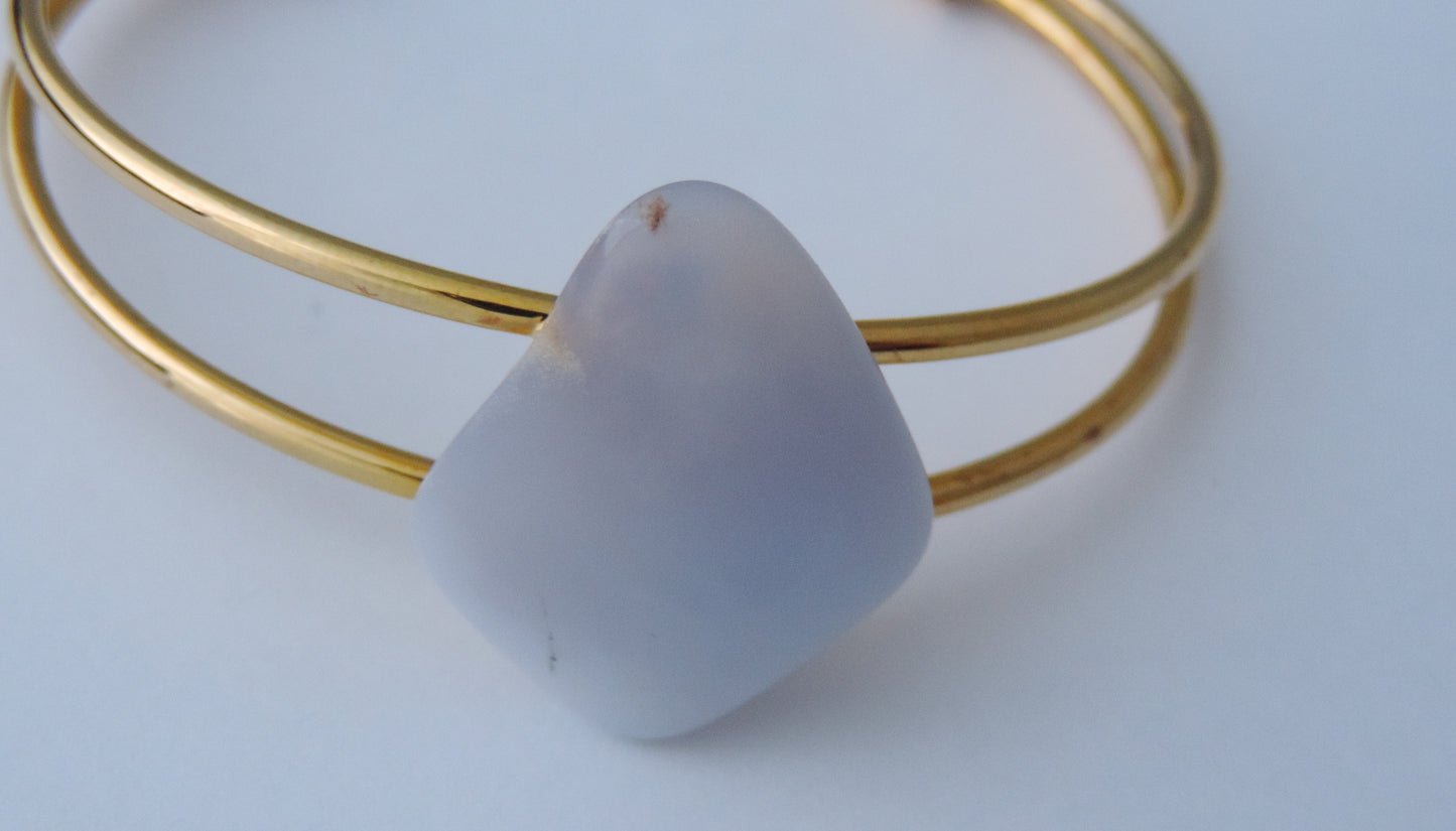 The translucent blue agate and its spectacular color variations have an alluring effect, many people find the stone naturally relaxing.  Original and unique in design, each piece is hand crafted by lapidary artists in Montana.      Our hand crafted jewelry is photographed next to a ruler for size.  This stone is a natural color, no dyes or heat treatment have been used.